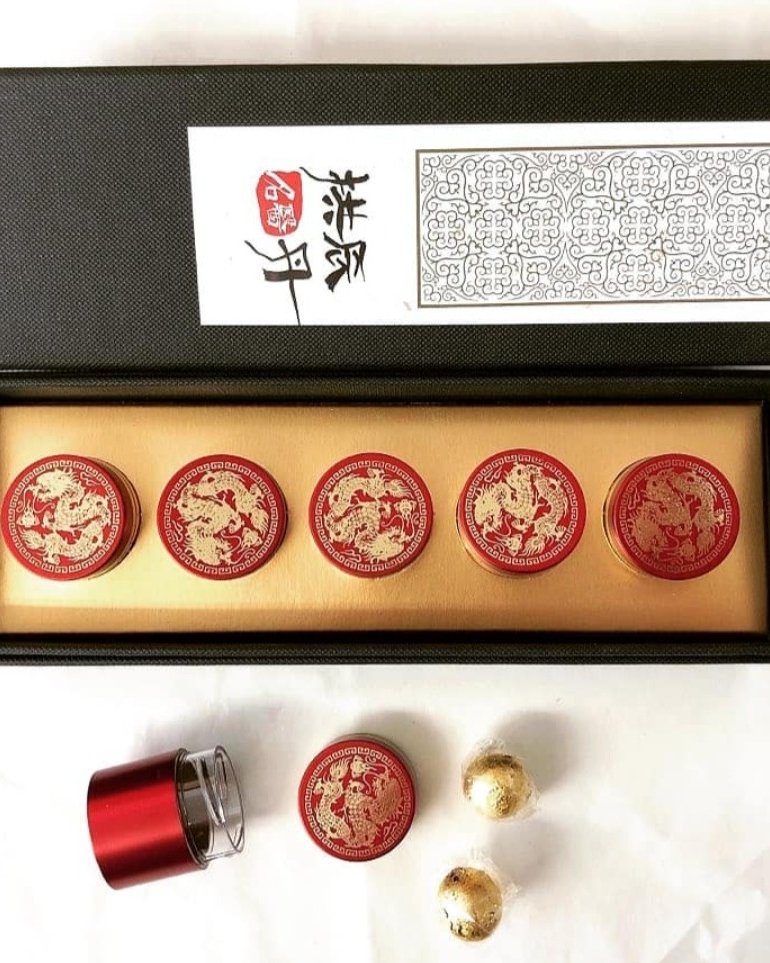 Open black-and-gold dragon presentation box with five ornate red-and-gold pill containers